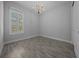Cozy bedroom with tile flooring, shuttered window, and chandelier for a stylish, comfortable space at 677 Brooks Field Dr, Winter Garden, FL 34787