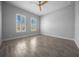Bright bedroom featuring wood-look tile flooring, a ceiling fan, and two windows with white shutters at 677 Brooks Field Dr, Winter Garden, FL 34787