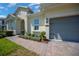 Inviting entryway featuring a modern glass door and decorative landscaping leading to the two-car garage at 677 Brooks Field Dr, Winter Garden, FL 34787
