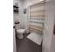 Cozy bathroom with neutral-striped shower curtain and gray tiled floors at 6846 Wilson Hammock Ave, Groveland, FL 34736