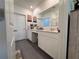 Bright bathroom with white cabinets, a vanity area, and gray tile flooring at 6846 Wilson Hammock Ave, Groveland, FL 34736