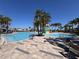 Community pool and splashpad surrounded by palm trees and lounge chairs, perfect for relaxation and recreation at 6846 Wilson Hammock Ave, Groveland, FL 34736