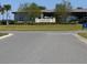The sign at the entry to Trinity Lakes Community with the amenity center in the background at 6846 Wilson Hammock Ave, Groveland, FL 34736