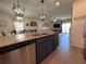 Kitchen island with stainless steel appliances and an open-concept floor plan with a dining and living area at 6846 Wilson Hammock Ave, Groveland, FL 34736