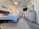 Bright main bedroom featuring plush carpet, dresser, TV, and decorative mirror at 6846 Wilson Hammock Ave, Groveland, FL 34736