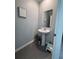 Small bathroom with gray walls, tile floor, and a pedestal sink at 6846 Wilson Hammock Ave, Groveland, FL 34736