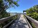 Picturesque wooden walkway leading to the lake, surrounded by lush greenery at 6846 Wilson Hammock Ave, Groveland, FL 34736