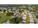 Expansive aerial view of a community featuring homes, green spaces, and a serene lake at 728 Tangerine Dr, The Villages, FL 32159