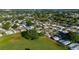 Scenic aerial view of a vibrant neighborhood with a picturesque pond and mature trees at 728 Tangerine Dr, The Villages, FL 32159
