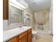 Bathroom features a single sink vanity, decorative mirror, and shower/tub combo at 728 Tangerine Dr, The Villages, FL 32159