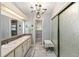 Bathroom with dual sinks, decorative tile, and glass-enclosed shower at 728 Tangerine Dr, The Villages, FL 32159