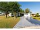 Attractive single-story home featuring a well-manicured lawn, mature trees, and an extended driveway at 728 Tangerine Dr, The Villages, FL 32159