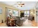 Cozy living room featuring tile floors, a ceiling fan, large windows, and comfortable seating at 728 Tangerine Dr, The Villages, FL 32159
