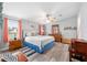 Bright main bedroom features stylish decor, wood-look floors, and a ceiling fan at 728 Tangerine Dr, The Villages, FL 32159