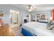 Spacious main bedroom with wood-look floors, en-suite bathroom, and mirrored closet doors at 728 Tangerine Dr, The Villages, FL 32159