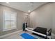 Bedroom with pilates machine, vaulted ceiling, window, and light gray walls at 7669 Chastain Cir, Middleton, FL 34762