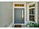 Inviting front entryway featuring a blue door, sidelight window, and charming welcome mat at 7669 Chastain Cir, Middleton, FL 34762