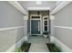 Inviting front entryway featuring a blue door, sidelight window, and charming plants at 7669 Chastain Cir, Middleton, FL 34762