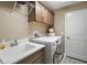 Functional laundry room equipped with a utility sink, storage cabinets, washer, and dryer at 7669 Chastain Cir, Middleton, FL 34762