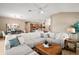 Bright and airy living room with a large sectional sofa, wood-look floors, and an open layout at 7669 Chastain Cir, Middleton, FL 34762