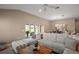 Comfortable living room with a sectional sofa, ceiling fan, and sliding glass doors to the outdoor living space at 7669 Chastain Cir, Middleton, FL 34762