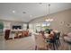 Open concept living space with living, dining, and kitchen areas featuring wood-look floors and neutral tones at 7669 Chastain Cir, Middleton, FL 34762