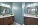 Bright bathroom with double vanities, light countertops and mirrors at 7669 Chastain Cir, Middleton, FL 34762