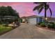 Charming home featuring a well-manicured front yard, inviting patio, and a two-car garage at 850 Oviedo Rd, Lady Lake, FL 32159