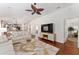 Open living room with TV, decorative fan, and wood floors, flowing into kitchen and hallway at 850 Oviedo Rd, Lady Lake, FL 32159