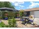 Inviting patio featuring a dining table with fire pit, and a privacy hedge around a screened-in pool at 850 Oviedo Rd, Lady Lake, FL 32159
