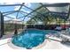 Sparkling backyard pool in screened enclosure features lush landscaping, patio furniture, and space for relaxation at 850 Oviedo Rd, Lady Lake, FL 32159