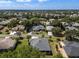 Panoramic aerial view of a well-maintained residential neighborhood showcasing lush greenery and meticulously landscaped properties at 8715 Se 176Th Lowndes Pl, The Villages, FL 32162