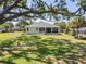 Expansive backyard featuring a well-manicured lawn, screened lanai, and mature landscaping, perfect for outdoor living at 8715 Se 176Th Lowndes Pl, The Villages, FL 32162
