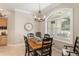 A dining room showcasing a rustic wooden table set beneath a modern chandelier, perfect for Gathering gatherings at 8715 Se 176Th Lowndes Pl, The Villages, FL 32162