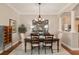 Elegant dining room with wood table, decorative mirrors, and chandelier under decorative ceiling trim at 8715 Se 176Th Lowndes Pl, The Villages, FL 32162