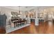 Dining room features an open plan with wood floors and view to the kitchen and living room at 8715 Se 176Th Lowndes Pl, The Villages, FL 32162