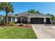 Charming single-story home boasts a well-manicured lawn, tasteful landscaping, and a convenient two-car garage at 8715 Se 176Th Lowndes Pl, The Villages, FL 32162
