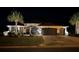 Exterior view of home showcasing manicured lawn, lush landscaping, and lighting at 8715 Se 176Th Lowndes Pl, The Villages, FL 32162