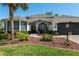 Inviting single-story home with well-maintained lawn, mature landscaping, and a two-car garage creates appealing curb appeal at 8715 Se 176Th Lowndes Pl, The Villages, FL 32162