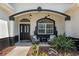 Charming front porch with seating area, decorative plants, and stylish lighting, creating an inviting entry at 8715 Se 176Th Lowndes Pl, The Villages, FL 32162