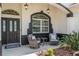 Cozy front porch features a seating area, decorative plants, and stylish overhead lighting for a welcoming entrance at 8715 Se 176Th Lowndes Pl, The Villages, FL 32162