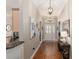 Warm hallway featuring hardwood floors, decorative artwork, and a view of the front entry at 8715 Se 176Th Lowndes Pl, The Villages, FL 32162