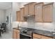 Contemporary kitchen with a gas range, tile backsplash, and natural wood cabinets at 8715 Se 176Th Lowndes Pl, The Villages, FL 32162