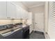 Well-equipped laundry room features modern washer, dryer, sink, and storage at 8715 Se 176Th Lowndes Pl, The Villages, FL 32162