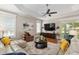 Cozy living room featuring a ceiling fan, wood floors, and slider doors leading to the outdoor space at 8715 Se 176Th Lowndes Pl, The Villages, FL 32162
