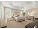A bright main bedroom features a tray ceiling, ample natural light, and a soothing color palette at 8715 Se 176Th Lowndes Pl, The Villages, FL 32162
