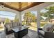 Screened-in patio has a couch and chairs to enjoy the view of the backyard's tropical landscaping at 8715 Se 176Th Lowndes Pl, The Villages, FL 32162