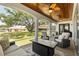 Covered outdoor patio with ceiling fans, comfortable seating, and view of the expansive backyard at 8715 Se 176Th Lowndes Pl, The Villages, FL 32162