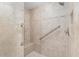 Accessible walk-in shower with built-in seat, grab bars, and neutral tile at 8715 Se 176Th Lowndes Pl, The Villages, FL 32162