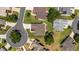 An overhead aerial view shows a home on a corner lot in a cul-de-sac with well-manicured lawns and mature trees at 929 Eastmont Ct, The Villages, FL 32162